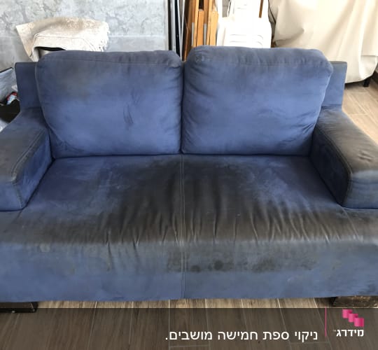ספה כחולה עם כתמים כהים על המושב והמשענות